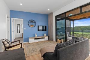 uma sala de estar com paredes azuis e um sofá em Tapuaetahi Beach Marvel - Te Tii Holiday Home em Waipapa