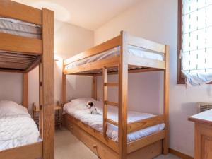 a bedroom with bunk beds with a dog laying on a bed at Spacieux appartement à Serre-Chevalier pour 6 pers. avec terrasse, parking couvert et wifi - FR-1-330E-74 in Le Villard-Late