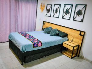 1 dormitorio con 1 cama con cabecero de madera en Acogedor loft frente al tranvía, en Medellín
