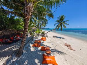 a beach with orange umbrellas and palm trees and the ocean at Mimosa Resort & Spa in Mae Nam