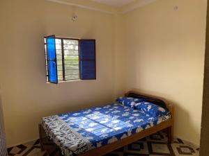 um pequeno quarto com uma cama e uma janela em Shubham guest house em Muzaffarpur