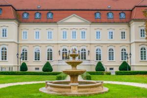 a fountain in front of a large building at La Contessa Castle Hotel in Szilvásvárad