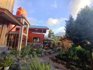 a house with a garden in front of it at Pelangi Guest House in Kayu Aro