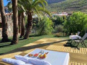 a table with a plate of fruit on a deck at Finca Aquilino y Carmen in Mogán