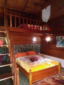 1 dormitorio con litera de madera y escalera en Pelangi Guest House, en Kayu Aro
