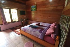 En eller flere senge i et værelse på Pelangi Guest House