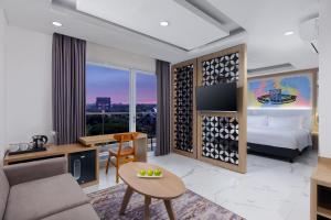 a hotel room with a king bed and a living room at favehotel Kediri in Kediri