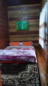 1 dormitorio con 1 cama con paneles de madera en Pelangi Guest House, en Kayu Aro