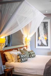 a bedroom with a canopy bed with pillows at Chobe Safari Lodges in Kasane
