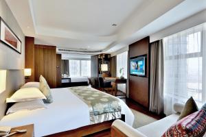 Una habitación de hotel con una cama grande y un escritorio. en SSAW Boutique Hotel Hangzhou Wildwind, en Hangzhou