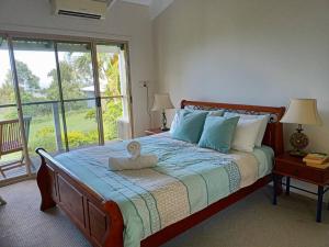 a bedroom with a bed with a teddy bear on it at Spectacular Gold Coast Skyline Views in Mount Tamborine