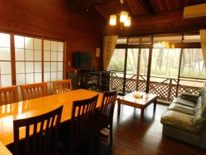uma sala de jantar com uma mesa e um sofá em 貸別荘「ブライト那須」 em Nasu