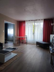 een woonkamer met een tafel en rode gordijnen bij L'appart in Limoges