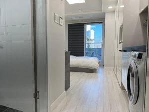 um quarto com uma cama e uma máquina de lavar e secar roupa em Central City em Incheon