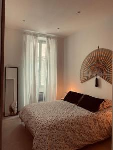 ein Schlafzimmer mit einem Bett und einem großen Fenster in der Unterkunft Au cœur de Marseille : superbe appartement ! in Marseille