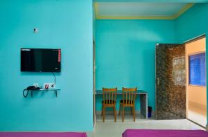 a room with a table and chairs and a blue wall at deb Guest House And Banquet hall in Kolkata