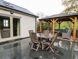 a table and chairs on a patio with a gazebo at Bryn Goleu in Llandudno