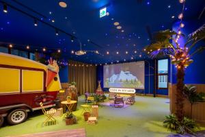 a room with a stage with a truck and a screen at Roaders Plus Hotel - Taipei Station in Taipei