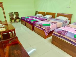 een kamer met drie bedden en een tafel bij โรงเกลือรีสอร์ท in Aranyaprathet