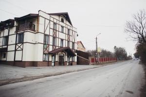 a brick building with a street sign on the side of it at Complex Zolota Pidkova in Zolochiv