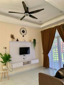 a living room with a ceiling fan and a tv at Hawra Homestay Kota Bharu in Kota Bharu