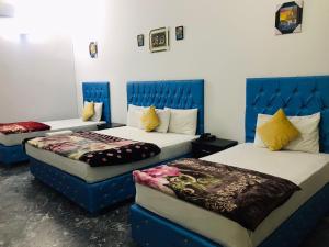 a hotel room with two beds with blue headboards at HOTEL ROSE INN in Lahore