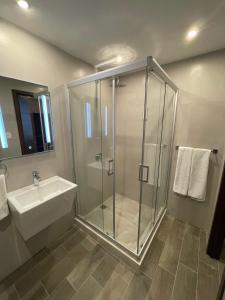a bathroom with a glass shower and a sink at Hotel Villas Santander in Guatemala