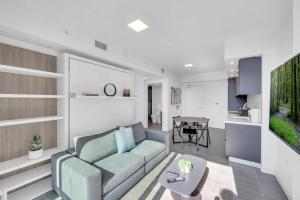 een woonkamer met een bank en een tafel bij Modern 1 Bed Condo across from Bayside in Downtown in Miami