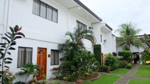 ein weißes Gebäude mit einem Innenhof mit Pflanzen in der Unterkunft Red Knight Gardens in Davao City