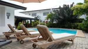 2 Liegestühle neben einem Pool in der Unterkunft Red Knight Gardens in Davao City