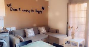 uma sala de estar com um sofá e uma placa na parede em Apartamento cerca del Mar em Poris de Abona
