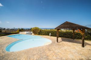 a swimming pool with a wooden gazebo and a swimming poolvisor at Ocean Nest T4 Rénové Vue Mer Splendide La Saline Les Bains in La Saline les Bains