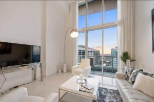 a white living room with a large window at Beautiful One Bedroom Condo 16ft ceilings at the W in Miami