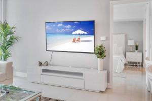 a living room with a tv on a white wall at Modern 1 Bed ICON Brickell with Amazing Views in Miami