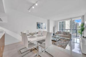 a white dining room with a white table and chairs at Modern 1 Bed ICON Brickell with Amazing Views in Miami