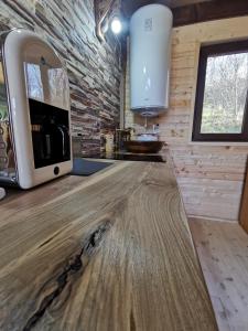 a kitchen with a wooden counter and a microwave at Casuta dintre nuci 