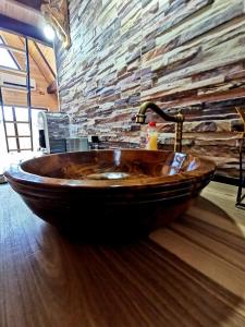 a wooden sink in a room with a stone wall at Casuta dintre nuci 