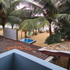 a view of a beach with a pool and palm trees at The Ocean in Galle