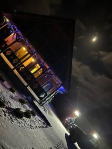 ein Auto, das nachts auf einer schneebedeckten Straße parkt in der Unterkunft Chata na Czarnym Groniu in Korbielów