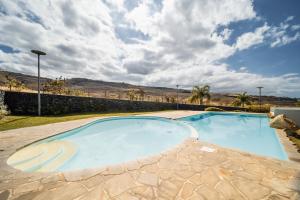 a large swimming pool in a yard with a cloudy sky at Ocean Nest T4 Rénové Vue Mer Splendide La Saline Les Bains in La Saline les Bains