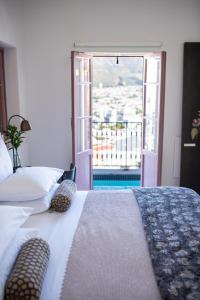 a bedroom with a bed with a view of a balcony at Dorp Hotel in Cape Town