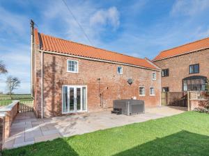 a brick house with a tv in a yard at Owl Barn in Benington