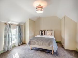 1 dormitorio con cama y ventana grande en Owl Barn, en Benington