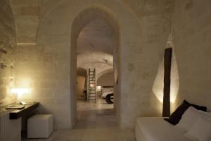 a living room with a white couch and an archway at Corte San Pietro in Matera