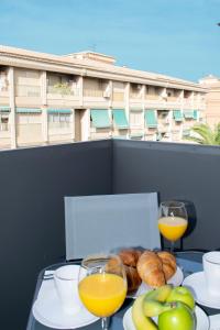 una mesa con un plato de comida y dos vasos de zumo de naranja en Deluxe Apartament Alcalá la Real, en Alcalá la Real