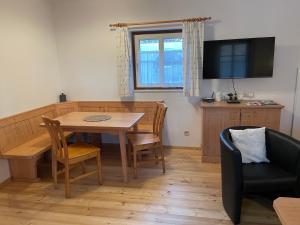 a living room with a dining room table and a television at Am Herrensee in Litschau