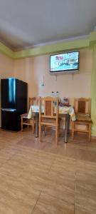a dining room with a table and chairs and a television at Apartament in Iaşi