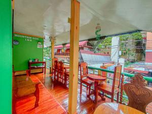 a restaurant with a table and chairs in a room at Mountain Side Inn in El Nido