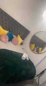 a bed with colorful pillows and a mirror at Spacious Double Room in prime location London in London