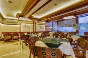 a restaurant with tables and chairs in a room at Hotel Amrit Residency in Indore